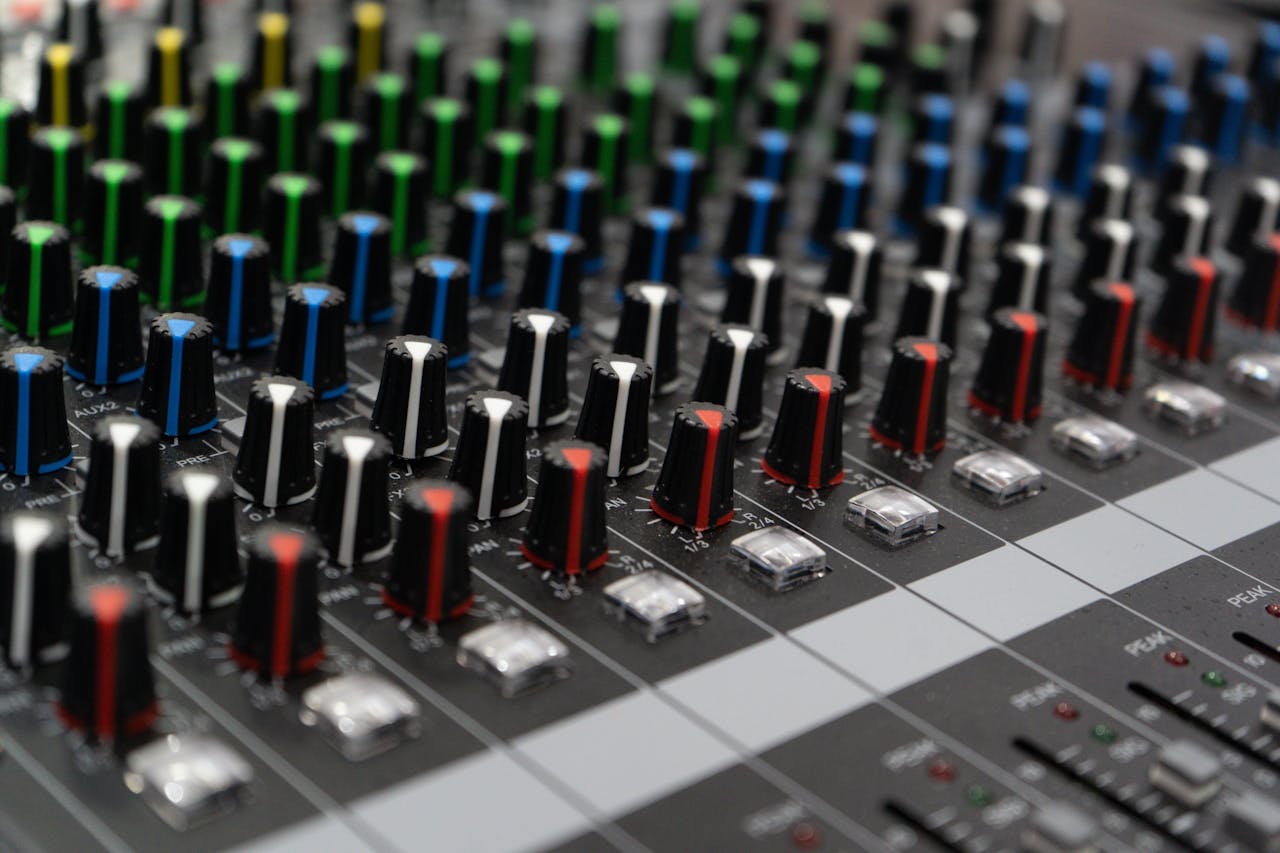 heros-img Detailed view of colorful dials on an audio mixing console, showcasing sound control technology.